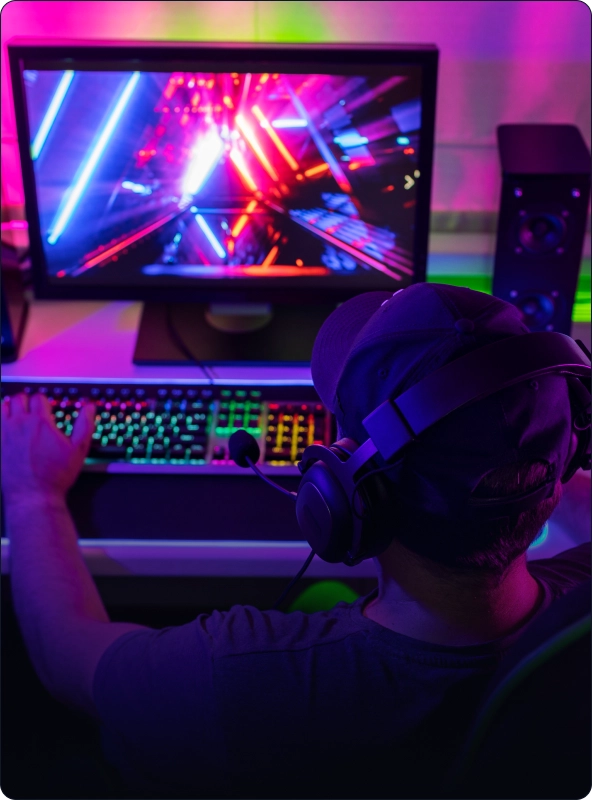 Gamer met headset achter een computer in een neonverlichte esports-opstelling